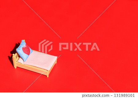 Decorated bed with pillow on red background. Decorated bed with pillow on red background. 131989101