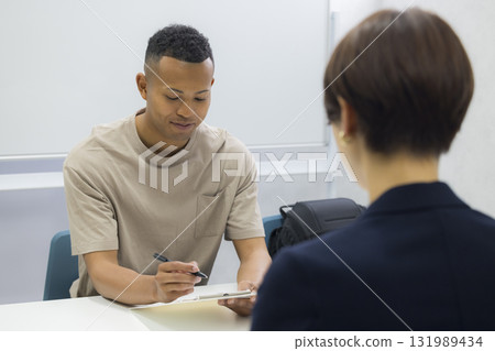 一名女子向一名外國男子解釋 131989434