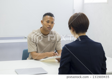 一名女子向一名外國男子解釋 一名女子向一名外國男子解釋 131989435