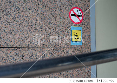 Signs for no smoking and wheelchair access, emphasizing health and accessibility in public spaces, promoting inclusive design and environmental consideration in modern buildings Signs for no smoking and wheelchair access, emphasizing health and accessibility in public spaces, promoting inclusive design and environmental consideration in modern buildings 131990299