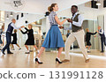 Woman with african man practising charleston dancing 131991128