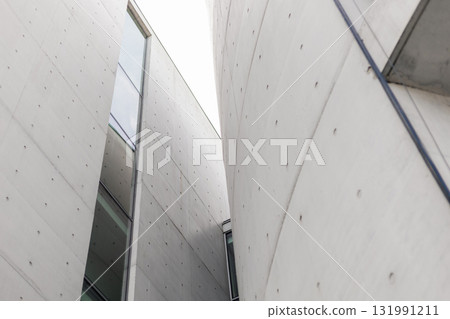 Structures with smooth concrete surfaces create an intriguing interplay of light and shadow. The design highlights angular forms and large glass elements, enhancing the modern aesthetic Structures with smooth concrete surfaces create an intriguing interplay of light and shadow. The design highlights angular forms and large glass elements, enhancing the modern aesthetic 131991211