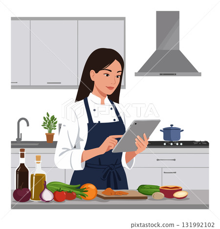 Woman Cooking in Modern Kitchen Using Tablet for Recipe with Fresh Vegetables and Olive Oil 131992102