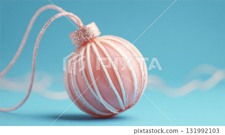 Pink Christmas ornament ball, glitter stripe detail, pastel blue background 131992103