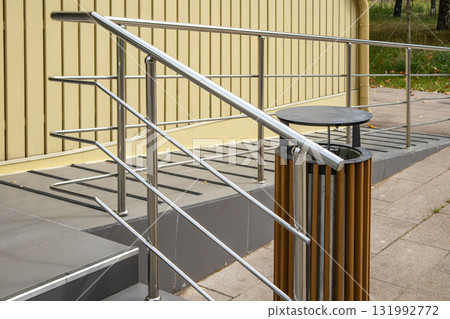 Stainless steel ramp handrails at building entrance accessibility, urban infrastructure 131992772