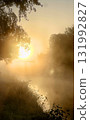 Experience the serene beauty of a stunning sunrise over a misty river landscape 131992827