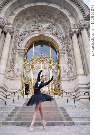 Ballet dancer posing in front of ornate Paris building  131992872