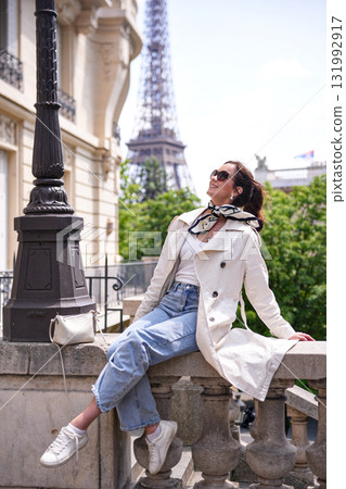 Joyful woman relaxing near Eiffel Tower in Paris Joyful woman relaxing near Eiffel Tower in Paris 131992917