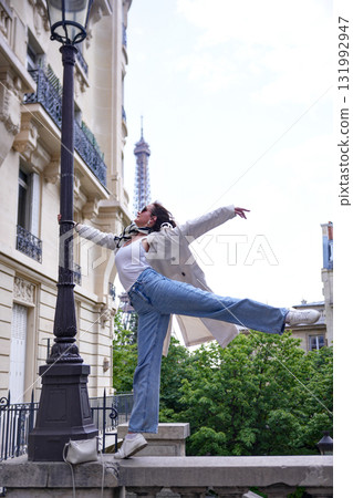 Graceful dancer performing on Paris street with Eiffel Tower view Graceful dancer performing on Paris street with Eiffel Tower view 131992947