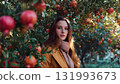 A woman farmer stands beneath a persimmon tree laden with bright red, juicy fruit, symbolizing bountiful harvest, nature's beauty, and organic produce. AI Generated 131993673
