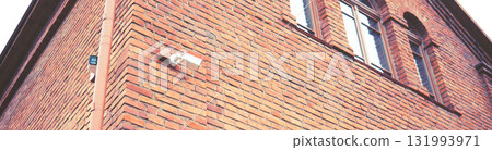 Security camera on the wall of a brick building Security camera on the wall of a brick building 131993971