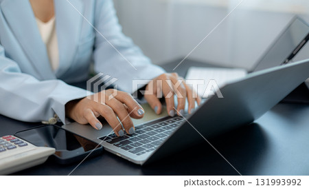 Professional businesswoman typing on laptop in modern office, digital technology and online communication concept 131993992