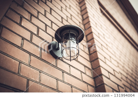 Street lamp on the wall of a brick building 131994004