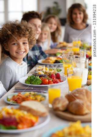 Family gathering with children enjoying delicious food at a long table Family gathering with children enjoying delicious food at a long table 131994218