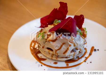 Fluffy pancake stack with cream, and salted caramel sauce, and topped red raspberry tuile Fluffy pancake stack with cream, and salted caramel sauce, and topped red raspberry tuile 131995101
