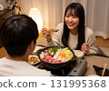 A woman with long black hair smiles while eating hotpot with her husband 131995368