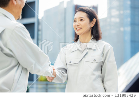 穿著工作服的男女握手 131995429