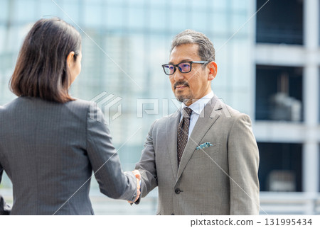 穿著西裝的男士和女士握手 131995434