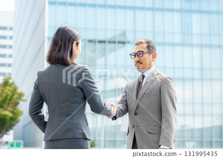 穿著西裝的男士和女士握手 131995435