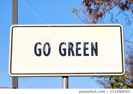 A sign, against a bright blue sky and foliage, displays the words GO GREEN, a call to action to embrace eco-friendly practices for a healthier planet A sign, against a bright blue sky and foliage, displays the words GO GREEN, a call to action to embrace eco-friendly practices for a healthier planet 131996093