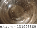An abstract, high-angle macro close-up shot looking down into a glass containing Champagne or sparkling wine 131996389