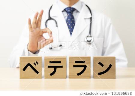A doctor making an OK sign and holding a block that says "veteran" A doctor making an OK sign and holding a block that says "veteran" 131996658