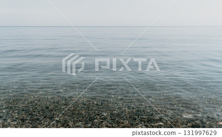 A calm body of water with a few rocks scattered throughout A calm body of water with a few rocks scattered throughout 131997629