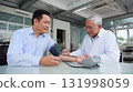young asian doctor checking blood pressure of elderly patient in modern clinic neutral tones 131998059