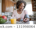 african american woman calmly checking blood pressure in kitchen daily routine 131998064