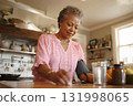 african american woman calmly checking blood pressure in kitchen daily routine 131998065