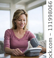 woman reviewing blood pressure numbers on digital monitor close up natural light 131998066