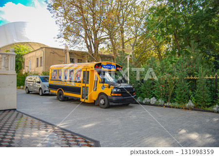 Yellow international school bus with welcome back to school message. A yellow school bus with a sign and inscription is parked on the school grounds. 131998359