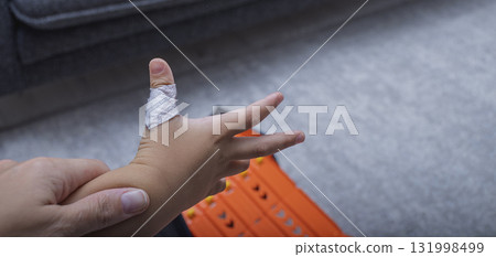 The child has a cut wound covered with a bandage The child has a cut wound covered with a bandage 131998499