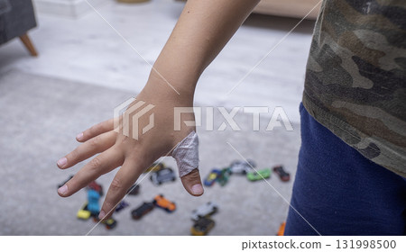 The child has a cut wound covered with a bandage The child has a cut wound covered with a bandage 131998500
