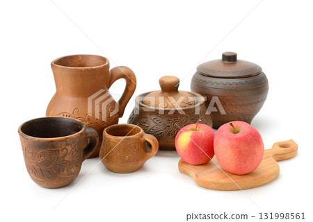 Traditional Earthenware Pottery with Floral Motifs and Fresh Apples Arranged on White Background for Culinary and Cultural Presentation 131998561