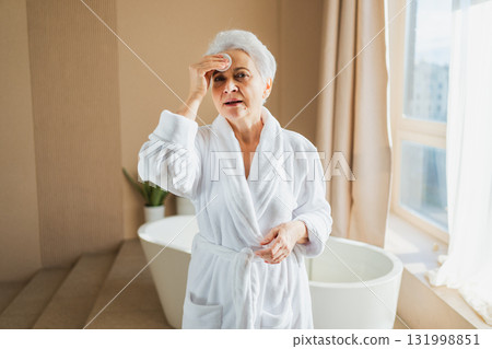 Mature adult old woman doing daily beauty routine removing makeup with cotton pad. Senior woman with lotion sponge washing face gets facial treatment. Skin care aging beauty skincare cleansing Mature adult old woman doing daily beauty routine removing makeup with cotton pad. Senior woman with lotion sponge washing face gets facial treatment. Skin care aging beauty skincare cleansing 131998851