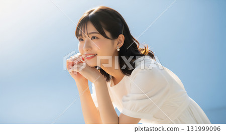 Portrait of a smiling woman against a refreshing light blue background 131999096