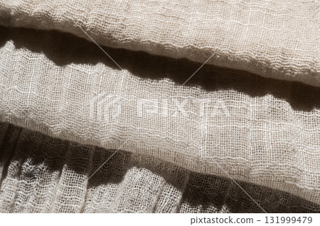 Close-up of soft, light-colored mesh fabric. The texture is visible, showcasing its delicate weave and airy quality. Close-up of soft, light-colored mesh fabric. The texture is visible, showcasing its delicate weave and airy quality. 131999479