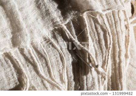 Close-up of soft, light-colored mesh fabric. The texture is visible, showcasing its delicate weave and airy quality. 131999482