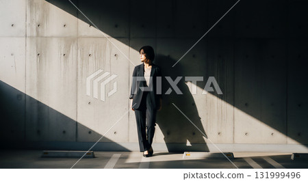 A woman in a black suit: A business portrait with striking light and shadow 131999496