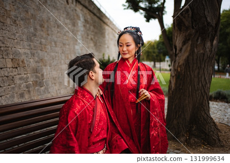 Happy interracial couple celebrating wedding day in traditional Hanfu attire 131999634
