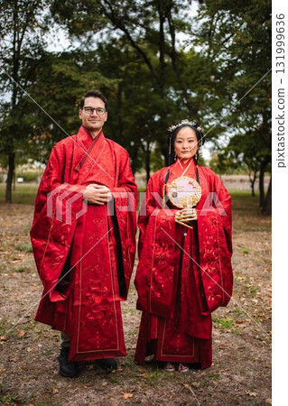 Man and woman celebrating an intercultural marriage ceremony in a park Man and woman celebrating an intercultural marriage ceremony in a park 131999636