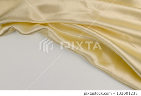 Golden fabric lies softly, highlighting its texture 132001235