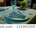 The table features a charming arrangement, with a crisp napkin carefully placed on the plate, ready for guests to enjoy their meal. 132001569
