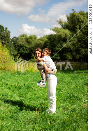 Carefree childhood moment. Preschool boy and mom twirl. Ideal for parenting and happiness themes. 132001616