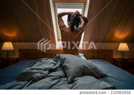 A peaceful and tranquil morning scene showcasing a person stretching leisurely in a cozy and inviting loft space A peaceful and tranquil morning scene showcasing a person stretching leisurely in a cozy and inviting loft space 132001656