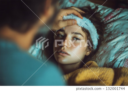 Caregiver Comforts a Sick Person in Bed During Early Morning Hours at Home 132001744