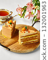 Two slices of orange cake with tea and flowers creating a cozy atmosphere 132001963