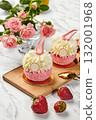 Delicious pink cakes with white cream and strawberries on wooden board 132001968