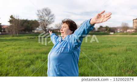 Concept of a healthy lifestyle and sports. Happy elderly woman in sports clothes, doing sports in the park. Side view. International Day of Older Persons Concept of a healthy lifestyle and sports. Happy elderly woman in sports clothes, doing sports in the park. Side view. International Day of Older Persons 132002074